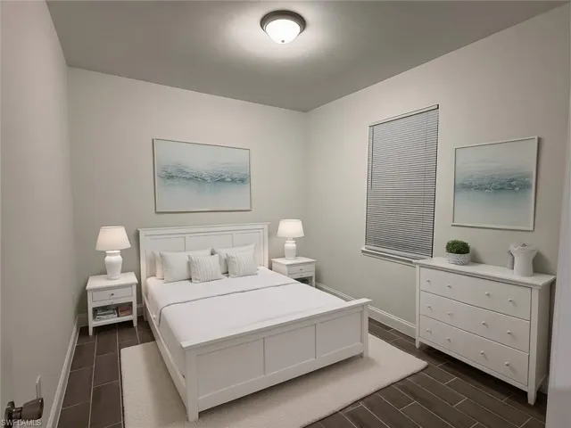 Bedroom featuring wood tiled floors and baseboards