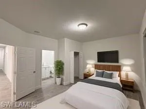 Bedroom with wood tiled floors and ensuite bathroom