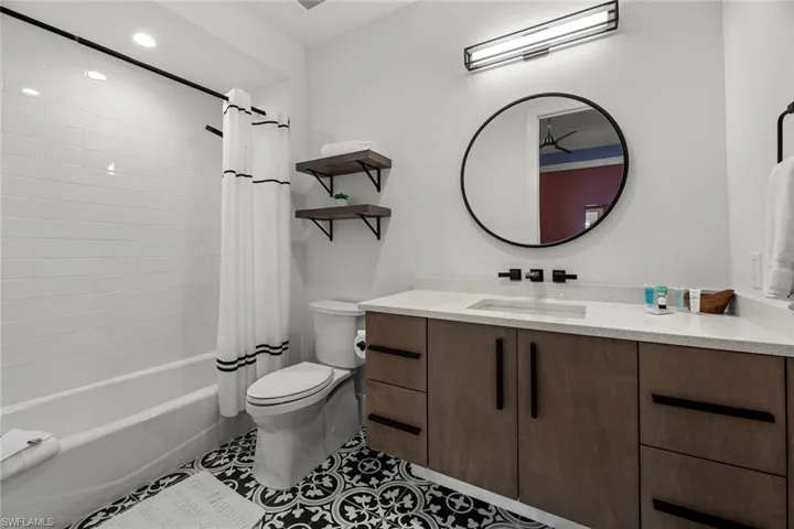 Full bathroom with tile floors, shower / bath combo, toilet, and vanity