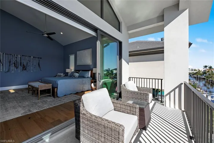 Balcony with outdoor lounge area, ceiling fan, and a water view