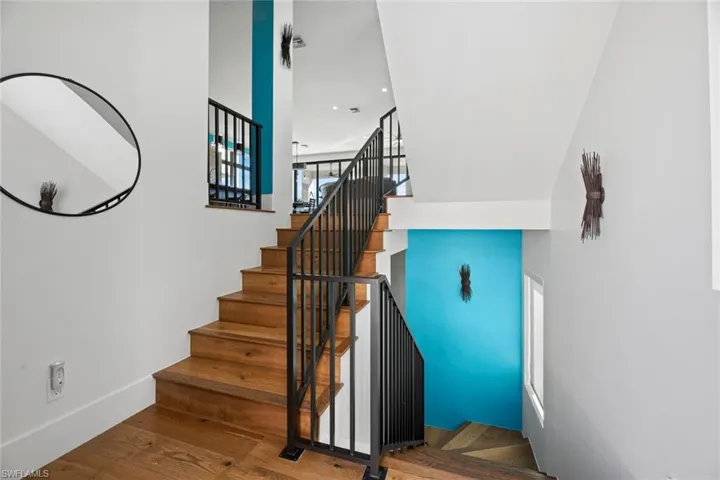 Stairs featuring a wealth of natural light and hardwood / wood-style floors