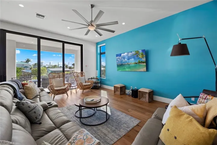 Living room with ceiling fan and hardwood / wood-style floors