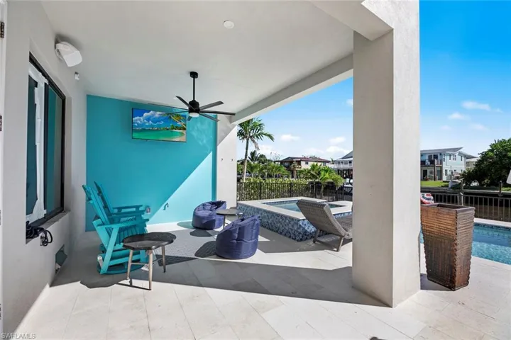 View of patio / terrace featuring ceiling fan and a swimming pool with hot tub