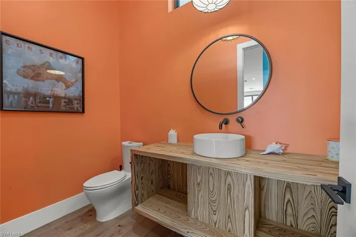 Bathroom with wood flooring, vanity, and toilet