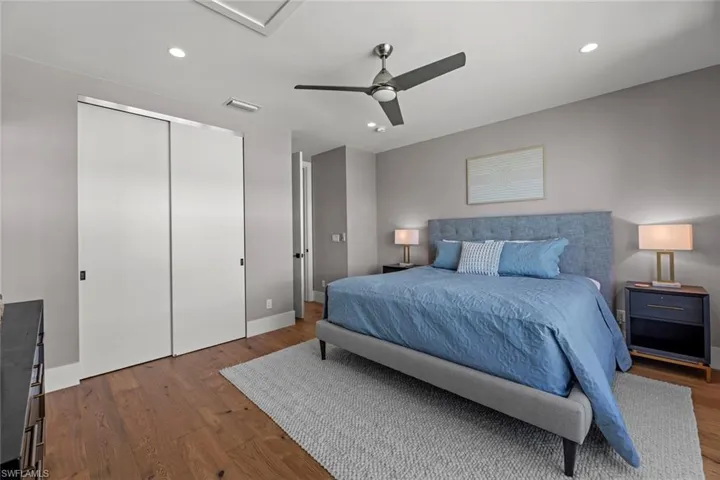 Bedroom featuring a closet, ceiling fan, and wood flooring