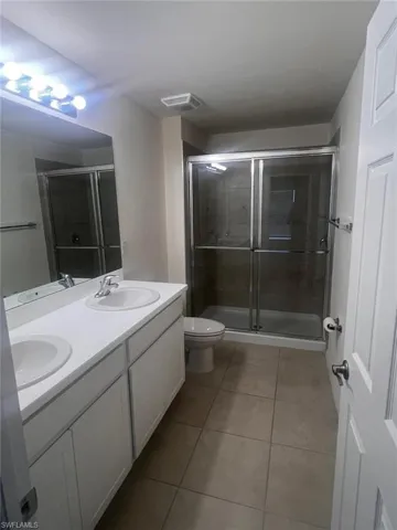 Kitchen with appliances with stainless steel finishes, sink, light wood-type flooring, white cabinetry, and a kitchen island with sink