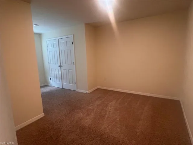 Bathroom featuring toilet, a shower with shower door, vanity, and tile patterned floors