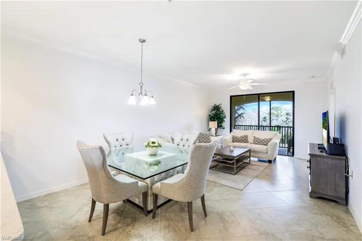 Dining area with crown molding, a ceiling fan, and a chandelier