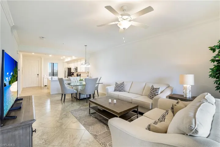 Living room with crown molding and ceiling fan