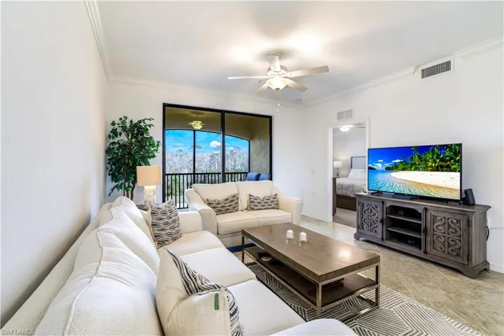 Living area with crown molding, ceiling fan, and tile patterned flooring