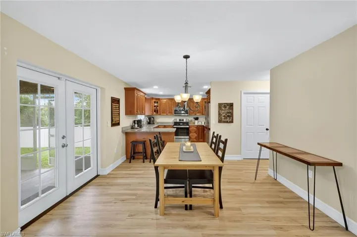 Dining room with a chandelier, french doors, light wood-type flooring, and recessed lighting