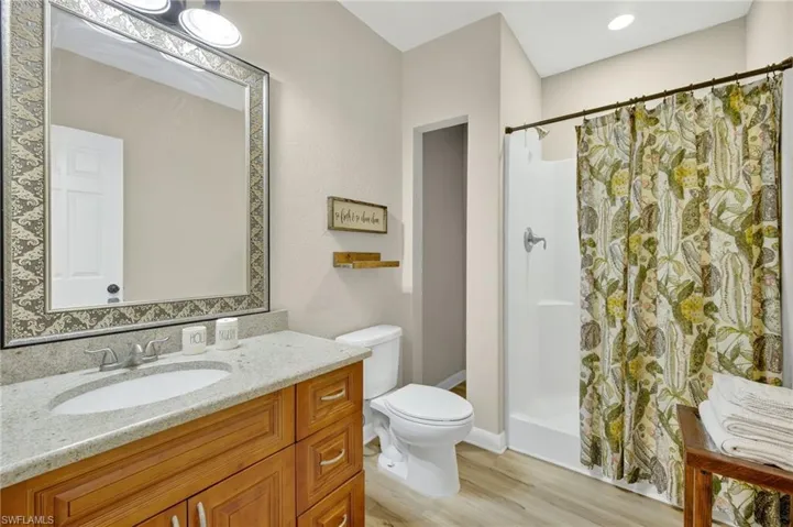 Bathroom featuring vanity, a shower with curtain, and wood finished floors