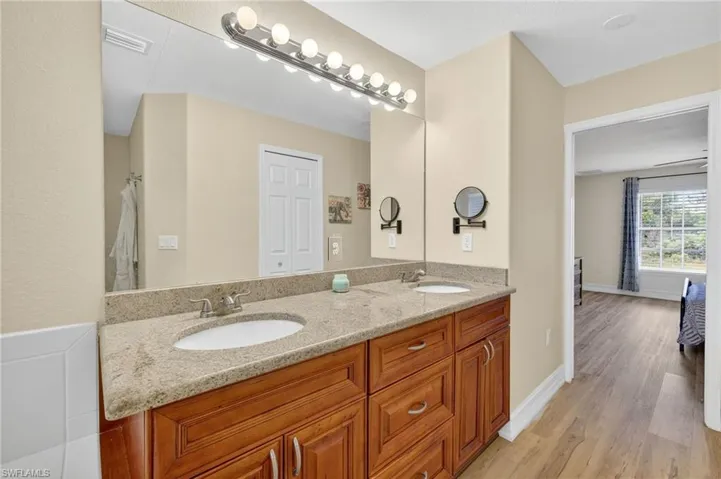 Bathroom featuring double vanity and wood finished floors