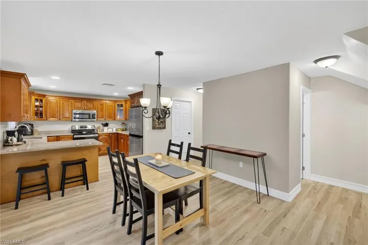 Dining room with light wood-type flooring, a chandelier, and recessed lighting