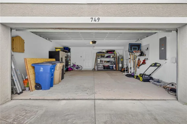 Garage featuring water heater and electric panel