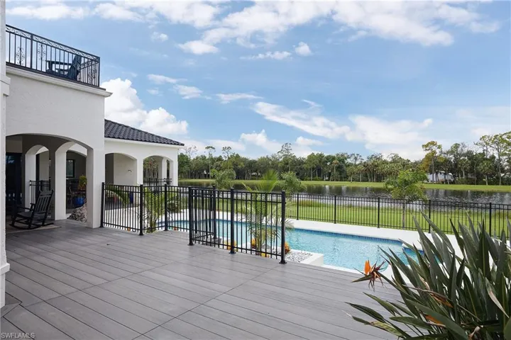 Expansive outdoor living area featuring a large pool, a composite decking surface.