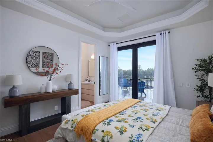 Room featuring tray ceiling, crown molding, and wood-finish flooring