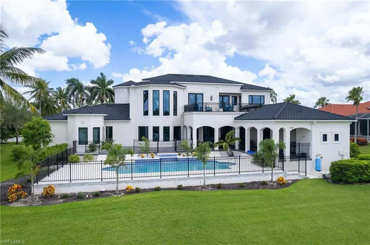 Stucco exterior featuring a dark tile roof and multiple balconies