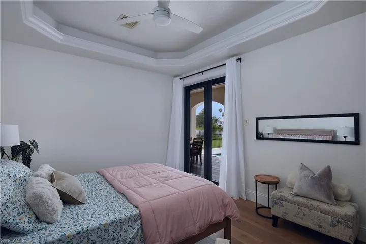 white oak flooring complementing a tray ceiling with crown molding