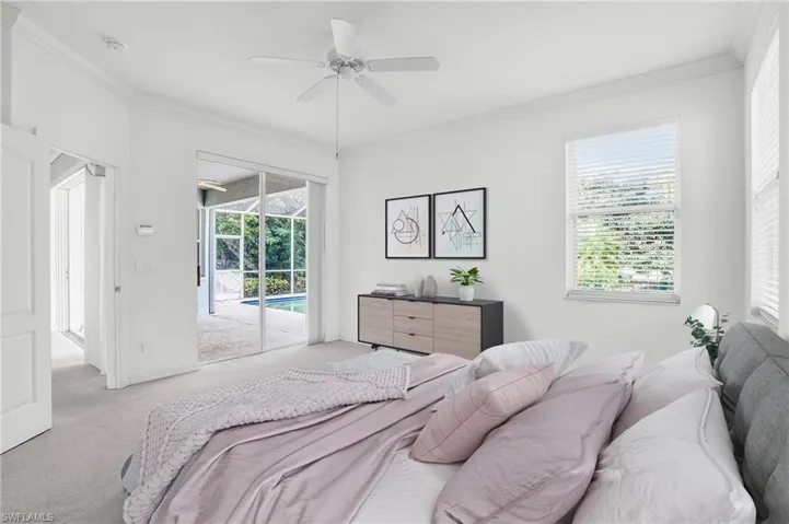 Bedroom with multiple windows, ornamental molding, access to outside, and light colored carpet