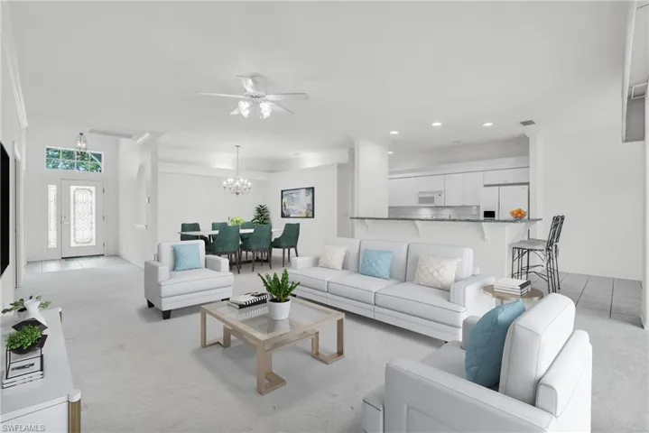 Living room featuring ornamental molding, light carpet, and an inviting chandelier
