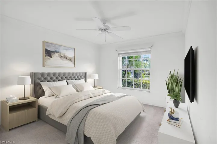 Bedroom with ceiling fan, ornamental molding, and light colored carpet