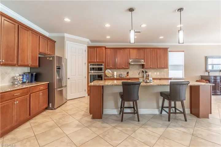 Kitchen featuring pendant lighting, a breakfast bar area, and a center island with sink