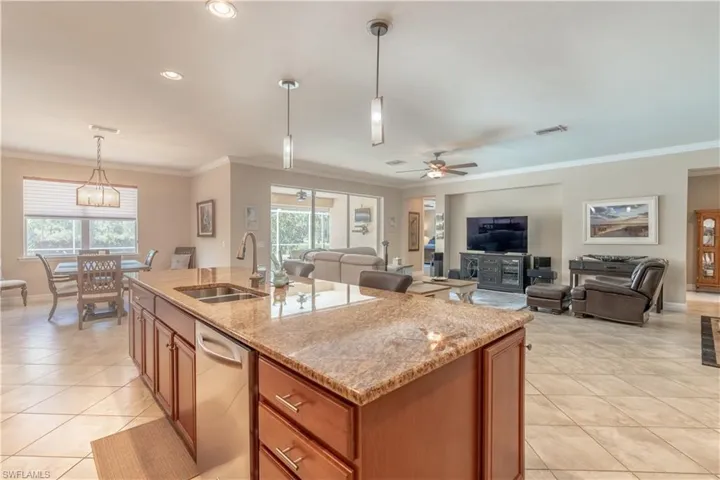 Kitchen featuring dishwasher, a kitchen island with sink, sink, and ceiling fan