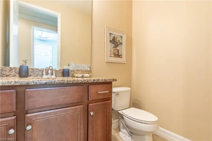 Bathroom featuring tile patterned flooring, toilet, and vanity