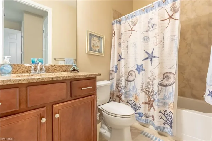 Full bathroom featuring vanity, toilet, and shower / bath combination with curtain