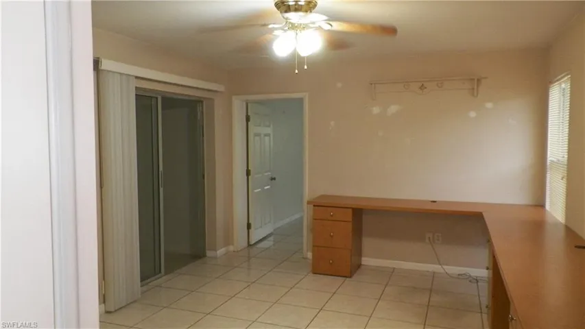 Tiled flooring throughout with a built-in wood-finish L-shaped desk