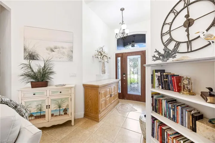 Foyer featuring a chandelier, high vaulted ceiling, and light tile patterned floors
