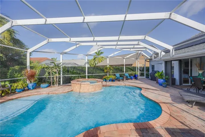 View of pool featuring a patio, a pool with connected hot tub, and a lanai