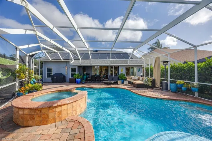 View of pool featuring an outdoor hangout area, a pool with connected hot tub, a patio area, and a lanai