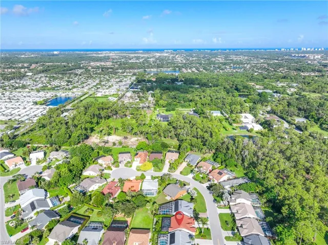 Aerial view of property's location featuring a nearby body of water and nearby suburban area