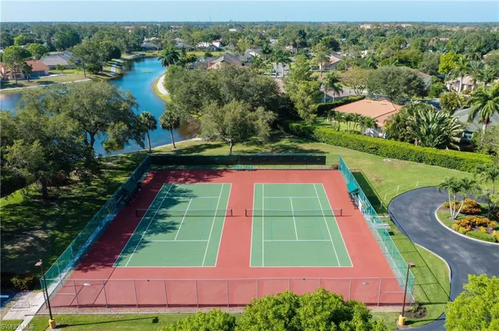 View of tennis court featuring a water view