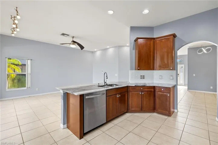 Kitchen featuring dishwasher, a ceiling fan, light tile patterned floors, decorative backsplash, and recessed lighting