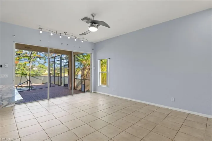 Spare room featuring a ceiling fan, light tile patterned floors, and rail lighting