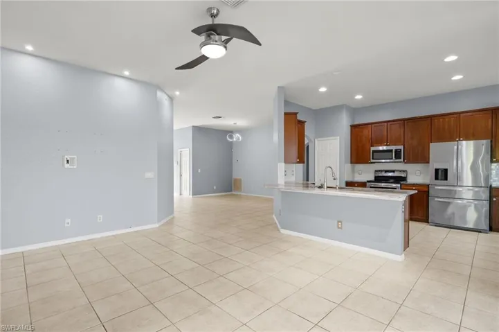 Kitchen featuring appliances with stainless steel finishes, a ceiling fan, recessed lighting, light countertops, and open floor plan