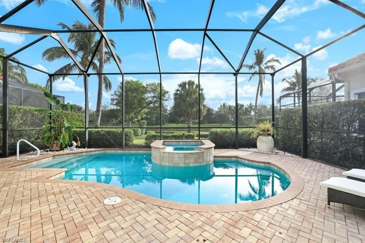 View of swimming pool with a sunroom, glass enclosure, a patio area, and a pool with connected hot tub