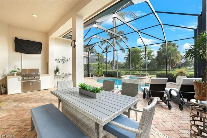 View of patio / terrace featuring outdoor dining space, a sunroom, glass enclosure, area for grilling, and a pool with connected hot tub