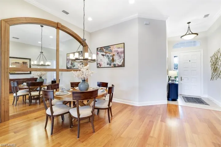 Dining room featuring light wood finished floors, a chandelier, ornamental molding, and recessed lighting
