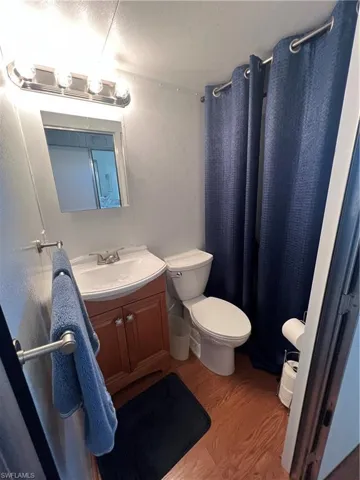 Half Bath with Wood Cabinetry and Closet Area