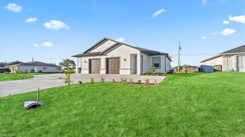 Modern farmhouse style home featuring a front yard, stucco siding, concrete driveway, and a garage