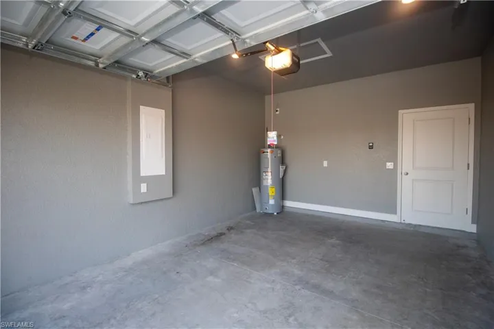 Garage featuring water heater and a garage door opener