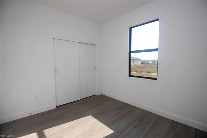 Bedroom featuring a closet and dark vinyl-style flooring