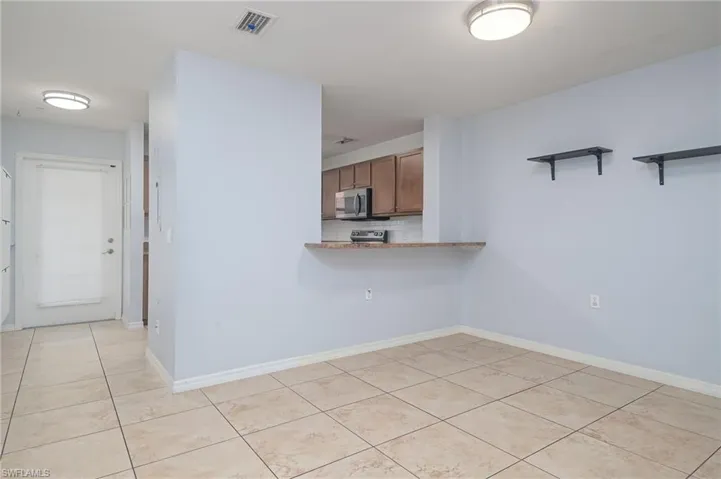 Kitchen featuring tasteful backsplash and light tile floors