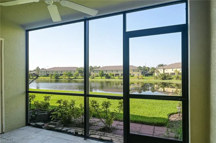 Unfurnished sunroom featuring a water view and ceiling fan
