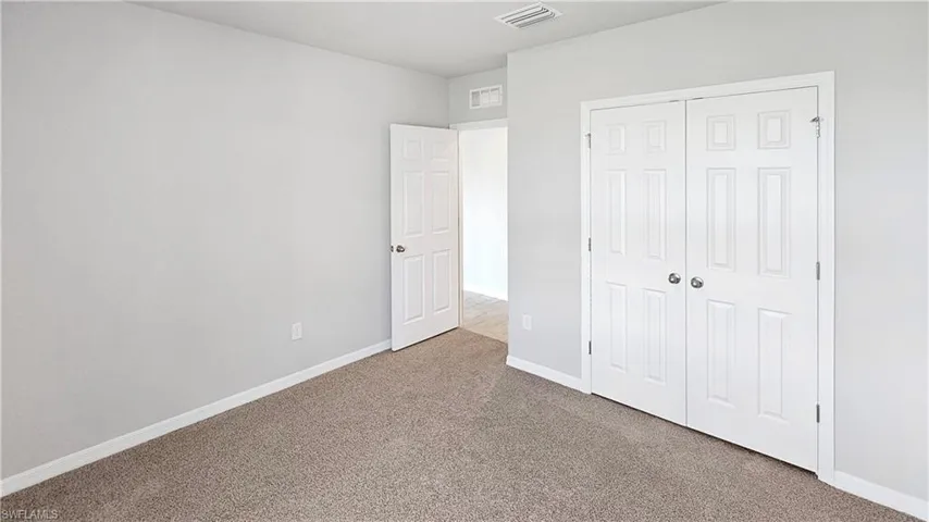 Unfurnished bedroom with a closet and carpet floors