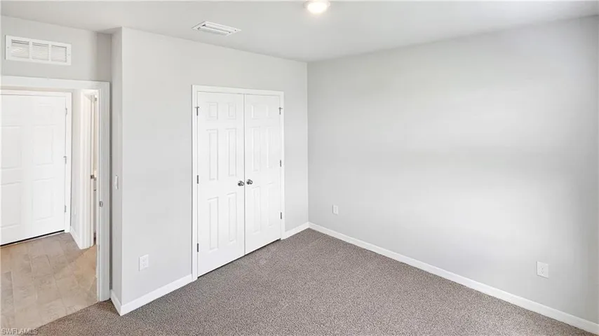 Unfurnished bedroom featuring carpet and a closet